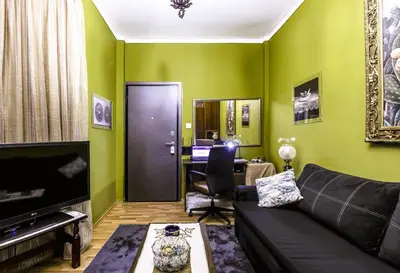a living room with green walls and a black couch at Premium GaLeRia 4A in Athens