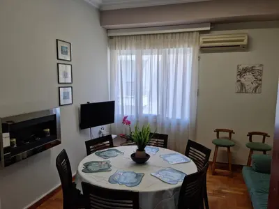 a living room with a table with chairs and a television at STADION APTS Near Athens City Center in Athens