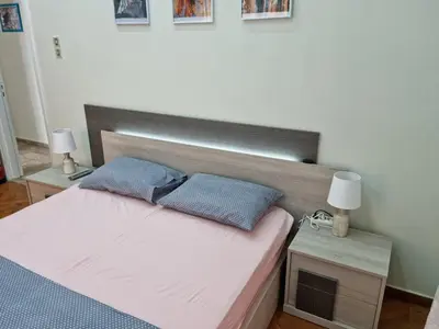 a bedroom with a bed with two blue pillows on it at STADION APTS Near Athens City Center in Athens