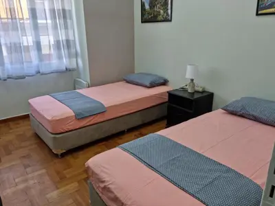 a bedroom with two beds and a lamp on a table at STADION APTS Near Athens City Center in Athens