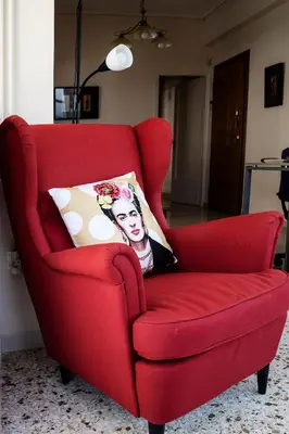 a red chair with a pillow in a living room at Ami's Appartment in Athens in Athens