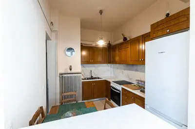 a kitchen with wooden cabinets and a white counter top at Ami's Appartment in Athens in Athens