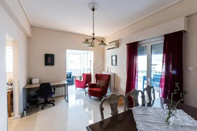 a living room with a dining table and red chairs at Ami's Appartment in Athens in Athens