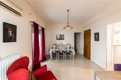 a dining room with a table and red chairs at Ami's Appartment in Athens in Athens
