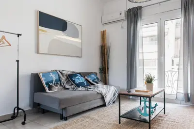 a living room with a couch and a table at Aegean style, city center studio next to Acropolis in Athens