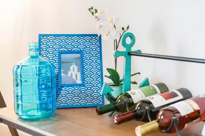 a table with a bottle of wine and a blue glass at Aegean style, city center studio next to Acropolis in Athens