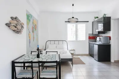 a living room with a table and a kitchen at Aegean style, city center studio next to Acropolis in Athens