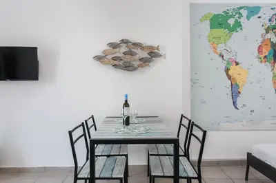 a dining room with a table and a world map on the wall at Aegean style, city center studio next to Acropolis in Athens