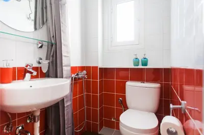 a bathroom with a white toilet and a sink at Aegean style, city center studio next to Acropolis in Athens