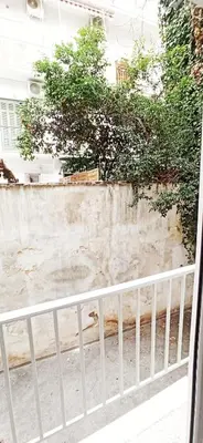 a white fence in front of a wall with trees at Athens' Secret Jewel by YHA in Athens