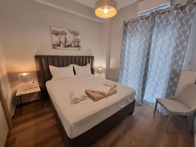 a bedroom with a bed with white sheets and a chair at Athens' Secret Jewel by YHA in Athens