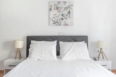 a bedroom with a white bed with two lamps at Lovely 2 bedroom rental in excellent location in Athens