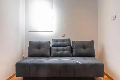 a blue couch in a room with a window at Lovely 2 bedroom rental in excellent location in Athens