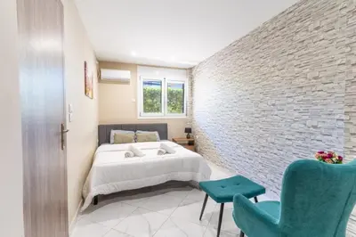 a bedroom with a bed and a brick wall at AIOLOS LUXURY alimos kalamaki market apartment 3 near the sea in Athens