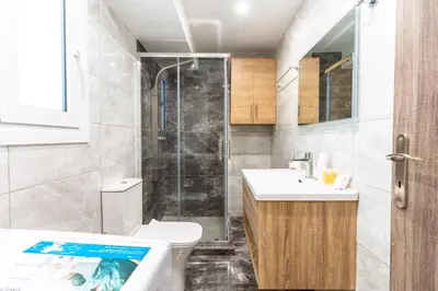 a bathroom with a shower and a toilet and a sink at AIOLOS LUXURY alimos kalamaki market apartment 3 near the sea in Athens