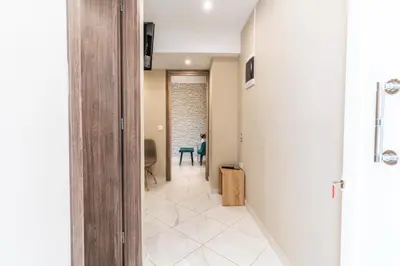 a hallway with a person sitting on a chair in a room at AIOLOS LUXURY alimos kalamaki market apartment 3 near the sea in Athens