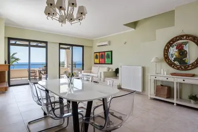 a dining room and living room with a table and chairs at Aphaia Villa & Residences Aegina in Agia Marina Aegina
