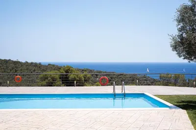 a swimming pool with a view of the ocean at Aphaia Villa & Residences Aegina in Agia Marina Aegina