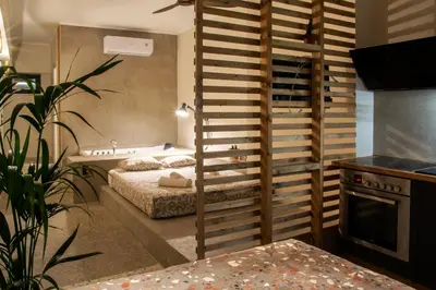 a bedroom with two beds in a room with a kitchen at Mosaics Athens aprtm in the Cetral Market in Athens
