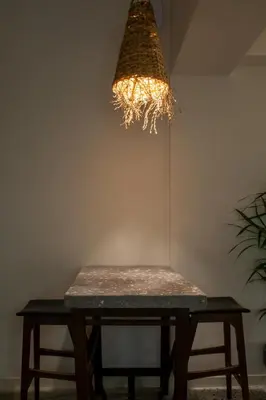 a table with two stools under a chandelier at Mosaics Athens aprtm in the Cetral Market in Athens