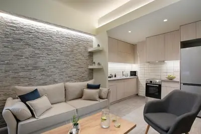 a living room with a couch and a kitchen at Le Centre Ville in Athens