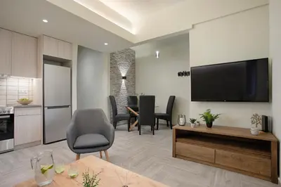 a living room with a television and a table with chairs at Le Centre Ville in Athens
