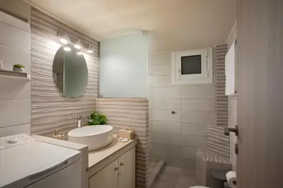 a white bathroom with a sink and a mirror at Le Centre Ville in Athens