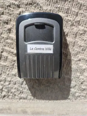 a black cell phone is hanging on a wall at Le Centre Ville in Athens