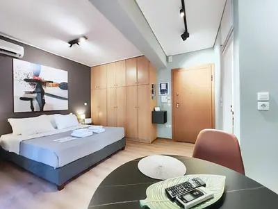 a bedroom with a bed and a table in a room at Veno Donwtown in Athens