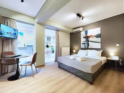 a bedroom with a bed and a desk and a table at Veno Donwtown in Athens