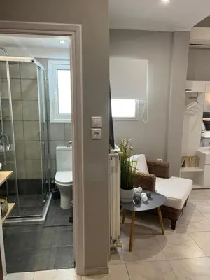 a bathroom with a shower and a living room at Living near Acropolis by Sylvia Staikou at Nikis str in Athens