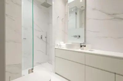 a white bathroom with a sink and a shower at Kalypso, Urban Apartment with Unique Views of The Acropolis! in Athens