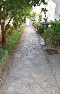 a cobblestone path in a yard with trees at Homeyfeel Stay Sea 1 - Modern studio next to the sea! in Porto Rafti
