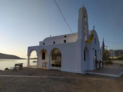 a white church with a building next to the water at Homeyfeel Stay Sea 1 - Modern studio next to the sea! in Porto Rafti