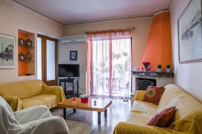 a living room with two couches and a fireplace at Sunny Apartment in Athens