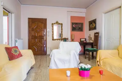 a living room with two white couches and a table at Sunny Apartment in Athens