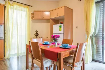 a kitchen with a wooden table with chairs and a red table cloth at Sunny Apartment in Athens