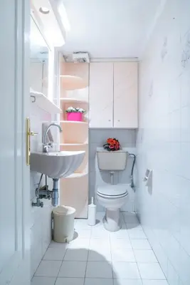 a white bathroom with a sink and a toilet at Sunny Apartment in Athens