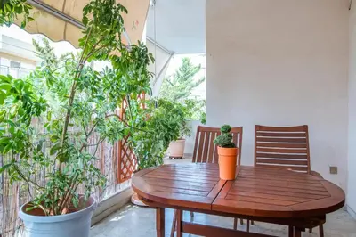a wooden table on a balcony with potted plants at Sunny Apartment in Athens