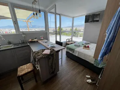 a bedroom with a bed and a desk and a sink at Square's View Agia Paraskevi in Athens