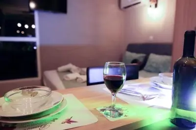 a glass of wine sitting on a wooden table at Square's View Agia Paraskevi in Athens