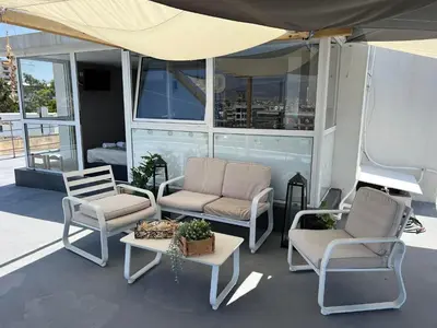 a patio with two chairs and a table and a couch at Square's View Agia Paraskevi in Athens