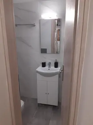a white bathroom with a sink and a mirror at Stylish apartment in Athens