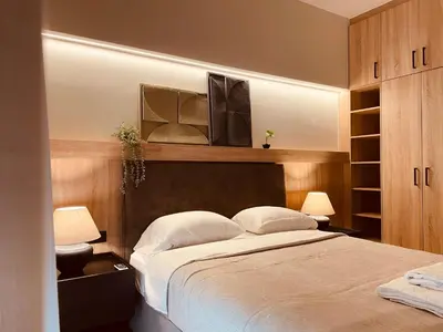 a bedroom with a bed with a television above it at 2 BedRoom Apt - Live Like a Local in Kolonaki in Athens