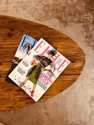a magazine sitting on top of a wooden table at 2 BedRoom Apt - Live Like a Local in Kolonaki in Athens