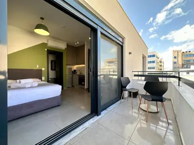 a bedroom with a bed and a table and chairs at M & M - boutique apartments in Athens