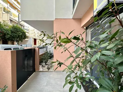 a plant in front of a building with a walkway at M & M - boutique apartments in Athens