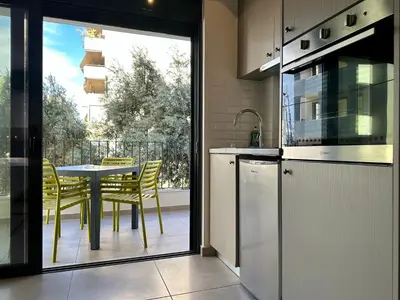 a kitchen with a table with chairs and a balcony at M & M - boutique apartments in Athens