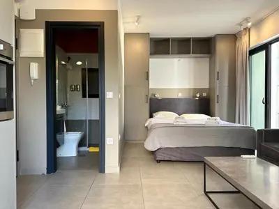 a bedroom with a large bed and a bathroom at M & M - boutique apartments in Athens