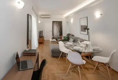 a living room with a table and chairs and a couch at Syntagma Apartments with Acropolis view in Athens
